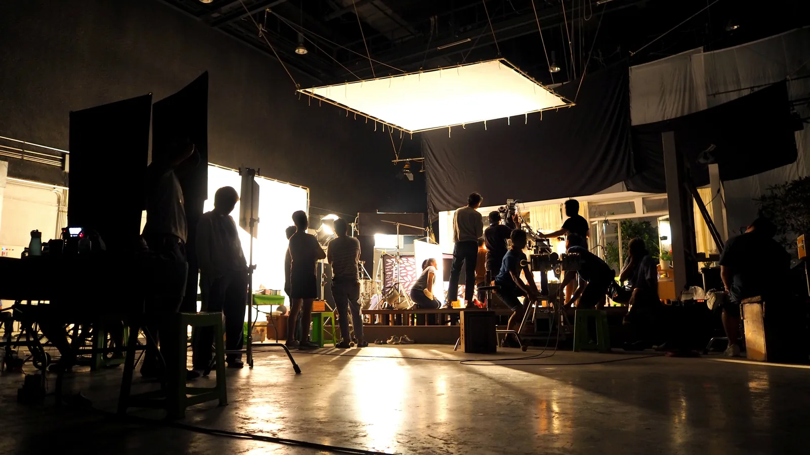 Film crew on a lit production set.